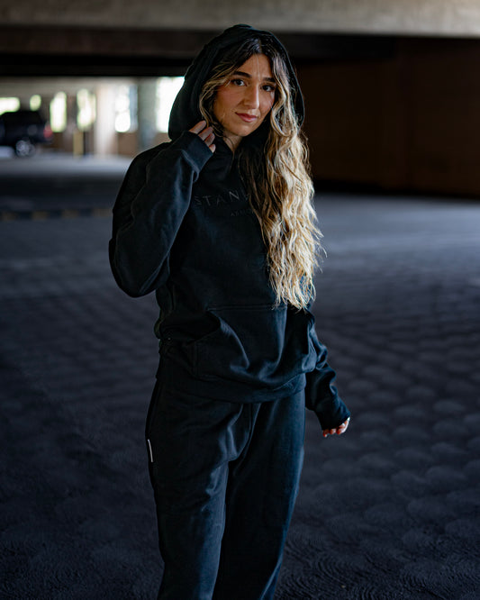 Model wearing Revelation Black Armor of God premium heavyweight hoodie