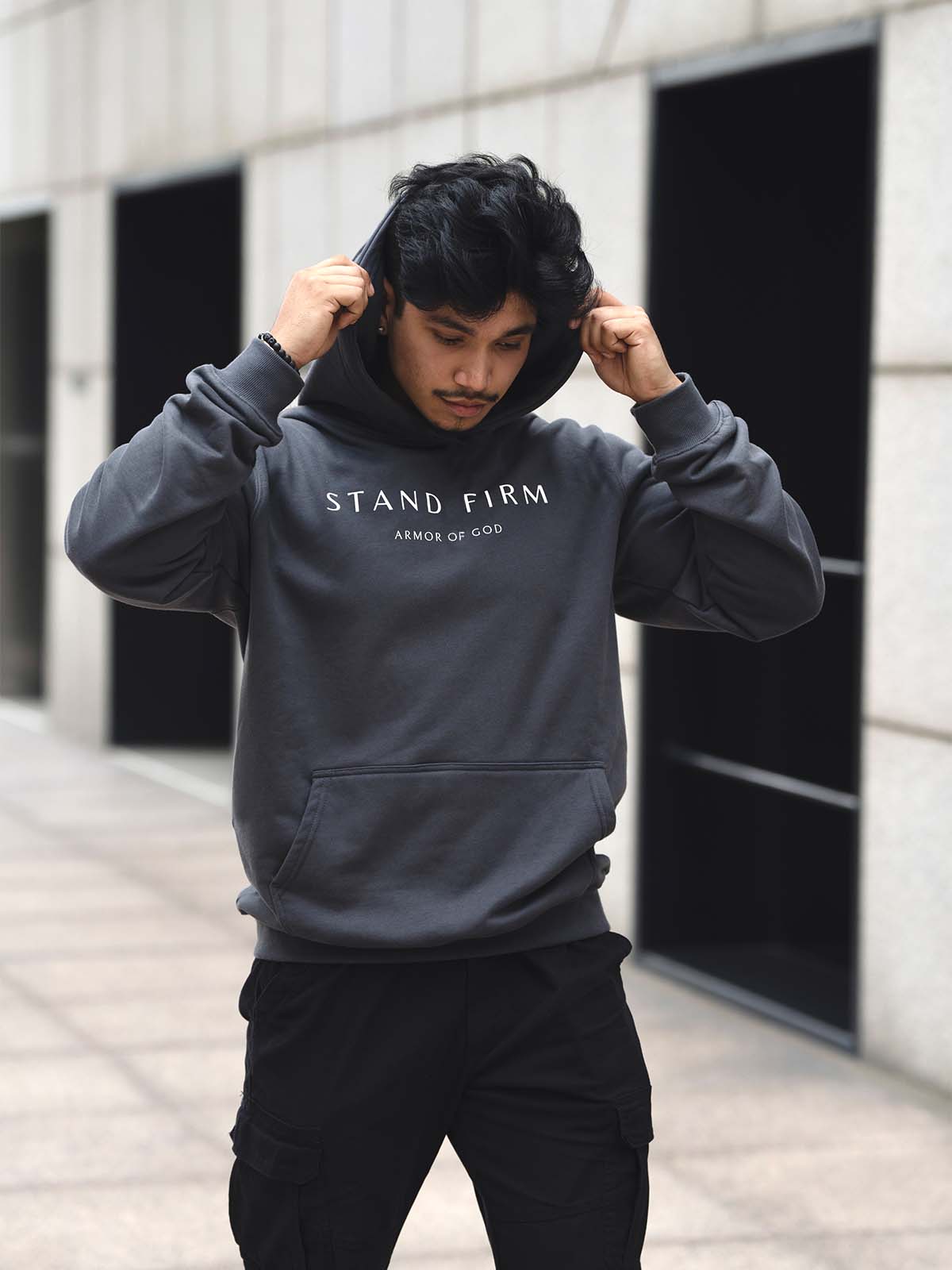 Model wearing Granite Gray Armor of God premium heavyweight hoodie