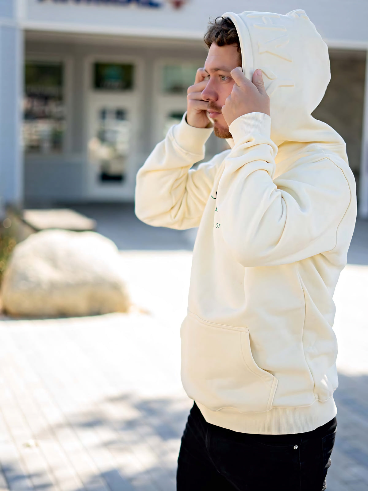 Model wearing cream Yahweh hoodie with Stand Firm chest print