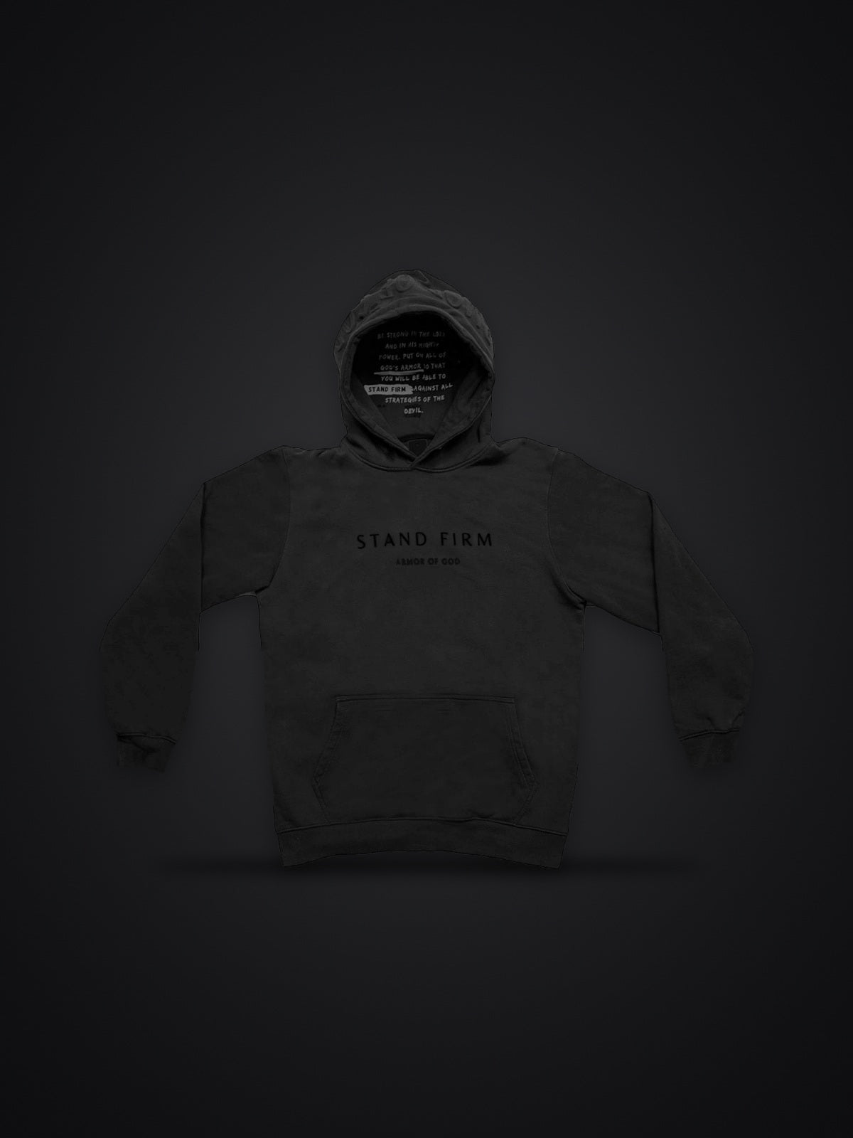 Revelation Black premium heavyweight hoodie, front view on dark background with Stand Firm chest print and verse inside the hood