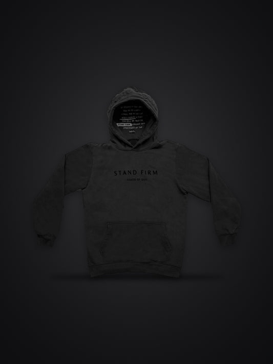 Revelation Black premium heavyweight hoodie, front view on dark background with Stand Firm chest print and verse inside the hood